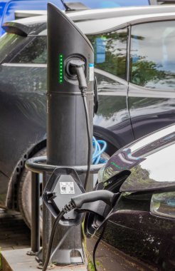 Edinburgh, İskoçya, 07.17.2024: Edinburgh 'da kaldırımlı bir caddenin şarj noktasında şarj olan siyah Mercedes elektrikli aracına yakın çekim