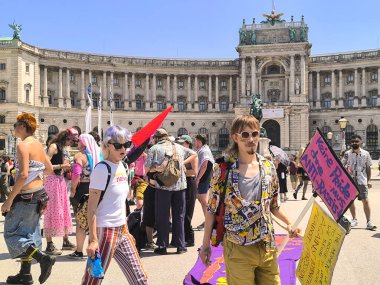 Viyana, Avusturya, 06.14.2025: Gençler güneşli bir günde Onur Günü yürüyüşü sırasında Heldenplatz 'daki Hofburg Sarayı önünde pankart ve pankartlarla bir araya geldiler