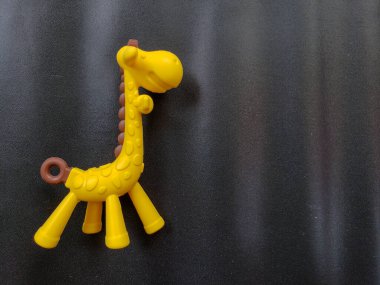 Parlak sarı bir zürafanın, dokulu, koyu bir arka plana bağlı, tepeden tırnağa çekilmiş bir fotoğrafı.