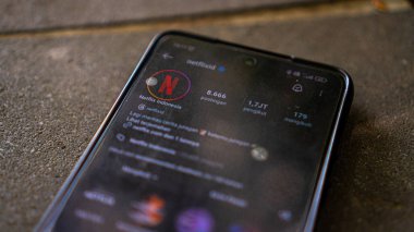 Bali, Endonezya - 20 Mart 2024: Netflix instagram logosu akıllı telefondan erkek ellerine yakın çekim