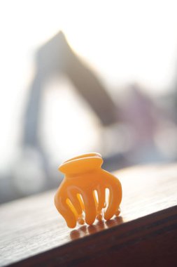 Masada turuncu plastik pençe saç tokası var..