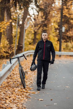 Güz parkında bisikletli genç, güzel atletik bir adam..