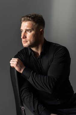 Siyah gömlekli bir erkek portresi.