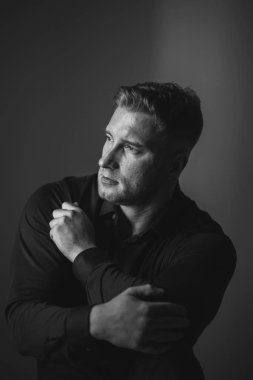 Siyah gömlekli bir erkek portresi.