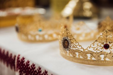 Rahip, gelin ve damadın parmaklarındaki alyansları kutsuyor. Düğün geleneği ve ritüeli. Kilisedeki genç bir çiftin elleri.