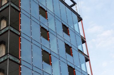 Roofer works on the roof structure of a building at a construction site. Roofer uses an air gun or air gun and install Metal Sheet on a new roof in Asia.