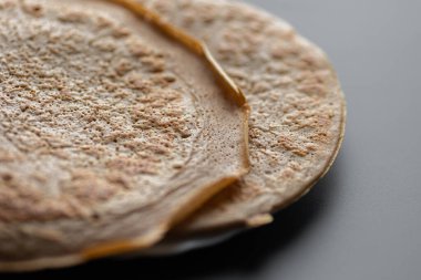 Üzerinde taze muz, ceviz ve bal dilimleri olan bir yığın yulaf ezmeli gözleme ve beyaz ahşap arka planda bir fincan çay. Sağlıklı bir kahvaltı. Boşluğu kopyala