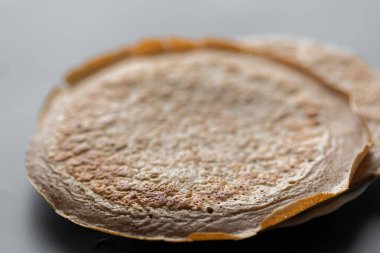 Üzerinde taze muz, ceviz ve bal dilimleri olan bir yığın yulaf ezmeli gözleme ve beyaz ahşap arka planda bir fincan çay. Sağlıklı bir kahvaltı. Boşluğu kopyala