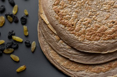 Üzerinde taze muz, ceviz ve bal dilimleri olan bir yığın yulaf ezmeli gözleme ve beyaz ahşap arka planda bir fincan çay. Sağlıklı bir kahvaltı. Boşluğu kopyala