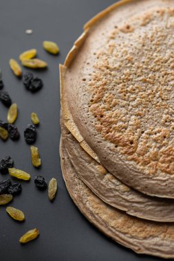 Üzerinde taze muz, ceviz ve bal dilimleri olan bir yığın yulaf ezmeli gözleme ve beyaz ahşap arka planda bir fincan çay. Sağlıklı bir kahvaltı. Boşluğu kopyala