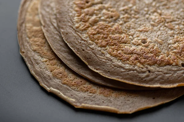 stock image A stack of oatmeal banana pancakes with slices of fresh bananas, walnuts and honey on top with cup of tea on a white wooden background. A healthy breakfast. Copy space