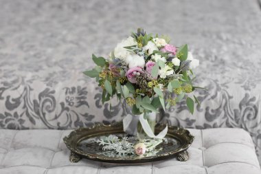 Düğün için. Evdeki gibi beyaz stüdyo içinde, güzel elbiseli gelin kanepede oturuyor. Modaya uygun bir düğün fotoğrafı. Genç, beyaz, esmer bir model, gelin gibi.