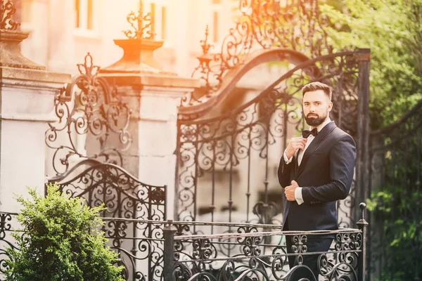 stock image Portrait of handsome Chinese young man in light blue suit and white undershirt walking and looking away with modern city buildings background in sunny day, side view of confident businessman.