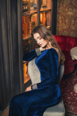 Son moda altın payetli parti elbisesi içinde zarif ve lüks bir kadının portresi. Zarif dalgalı saç stili, parlak makyaj, kırmızı dudaklar. Havalı bir akşam çantası..