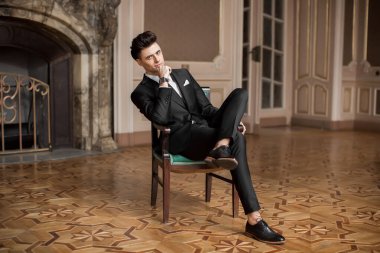 Güzel bir odada yeni takım elbiseli yakışıklı bir erkek.