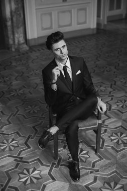 Güzel bir odada yeni takım elbiseli yakışıklı bir erkek.