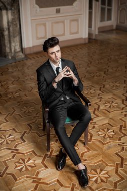 Güzel bir odada yeni takım elbiseli yakışıklı bir erkek.