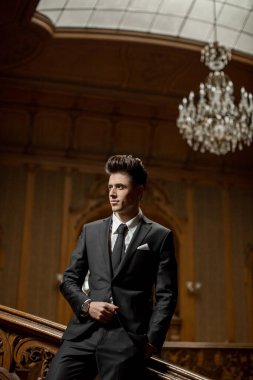 Güzel bir odada yeni takım elbiseli yakışıklı bir erkek.