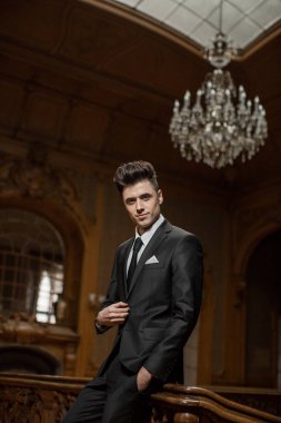 Güzel bir odada yeni takım elbiseli yakışıklı bir erkek.