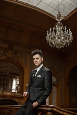 Güzel bir odada yeni takım elbiseli yakışıklı bir erkek.