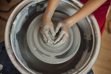 Çömlek atölyesinde, el sanatları ve kil sanatı, çocuk yaratıcı aktiviteler, sanat eğitimi gibi konularda modellik yapan sevimli bir çocuk.