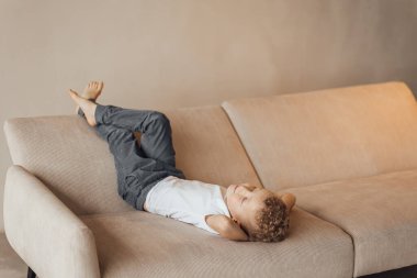 Sarı koltuklu küçük sarışın bir çocuk gülümseyerek başka tarafa bakıyor. Mesaj için yer var. Uluslararası Çocuk Günü