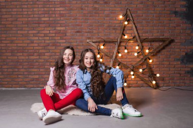 Stüdyoda parlak arka planda dururken gündelik modaya uygun giyinen bir grup oyuncu çoklu-ırkçı çocuk eğleniyor.