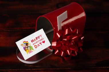 Kalp şeklinde süslemelerle çevrili kırmızı bir posta kutusu. Sevgililer Günü için mükemmel.. 