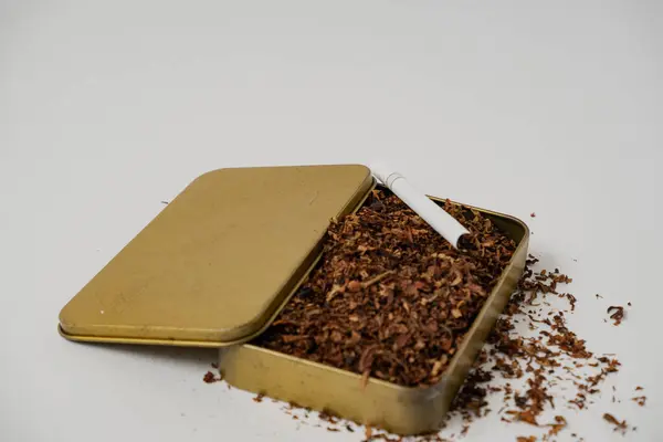 Etrafında beyaz arka planda sigara ve tütün var.