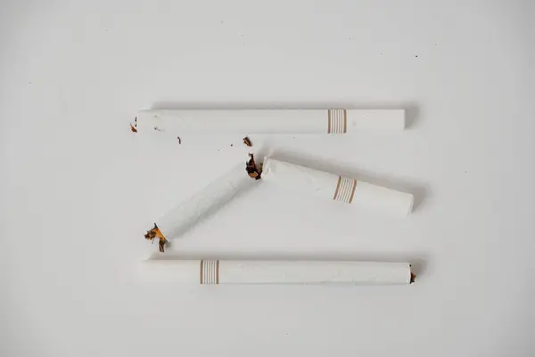 Beyaz arka planda kırık bir sigara.