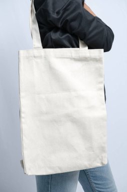 Birinin omzunda asılı sade beyaz bir çanta.