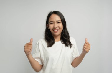 Gülümseyen ve baş parmağını kaldıran bir kadın.