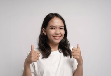 Büyük bir gülümsemeyle baş parmağını kaldıran bir kadın.