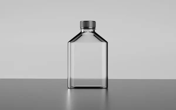  Gri bir yüzeyde duran siyah şapkalı cam bir şişe.