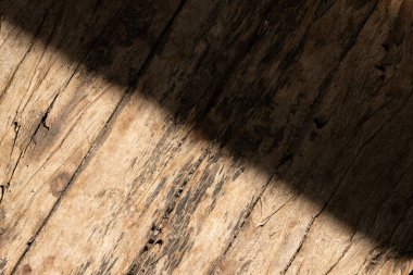 Yıpranmış ahşap kalasların üzerine düşen çapraz bir gölge.