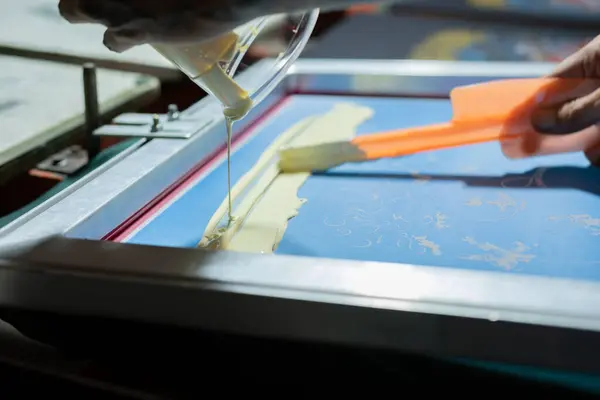 beyaz ekran yazdırma mürekkebi bir ekran yazdırma çerçevesine döküldü