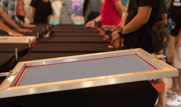 Black shirts laying flat on a printing table
