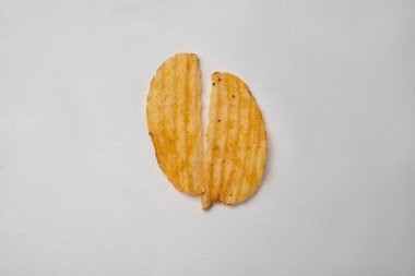 İki parçaya ayrılmış kırık patates cipsi.