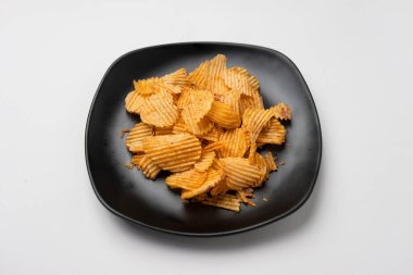 Siyah tabakta patates cipsi.