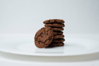 Beyaz tabakta bir yığın çikolatalı kurabiye.