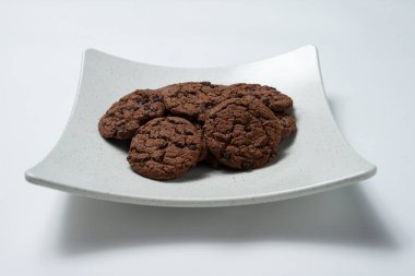 Çikolata parçacıklı kurabiyeler bir tabakta duruyor.