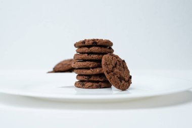 Çikolata parçacıklı kurabiyeler beyaz tabakta.