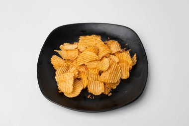 Siyah tabakta patates cipsi.