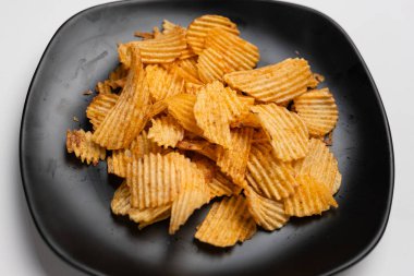 Siyah tabakta patates cipsi.