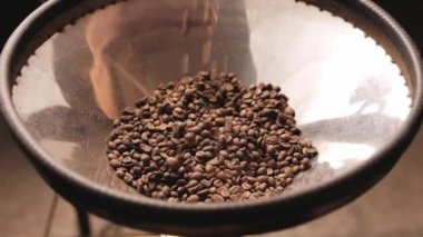 Bir el kahve çekirdeklerini fasulyeye döküyor.