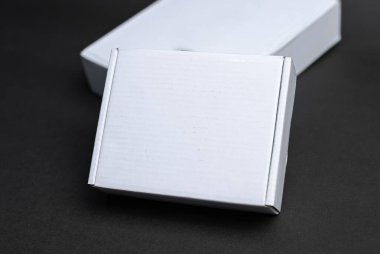 A white box packaging sitting on a black surface clipart