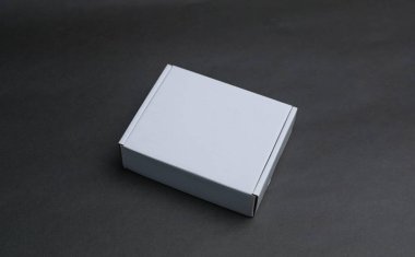 Beyaz bir kutu, karanlık bir yüzeyde yatıyordu.