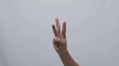 Kadın elleri parmaklarıyla sayıyor ve başparmağıyla kapalı.