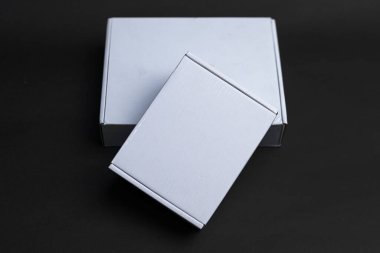 Birbirinin üstünde oturan iki kutu. Biri diğerinden biraz daha küçük. Küçük olan büyük olanın üstünde, küçük kutunun uzun tarafı var.