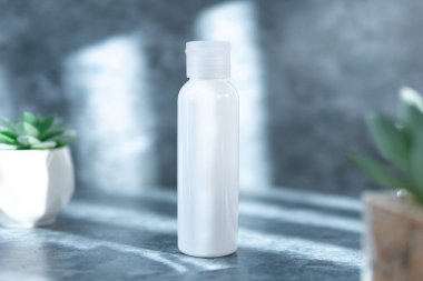 Beyaz boş kozmetik şişesi, nemlendirici losyon ya da çimento arka planında kurumuş çiçek olan şampuan. Doğal Organik Spa Kozmetik Konsepti